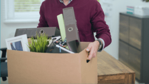 person packing up their office after losing their job