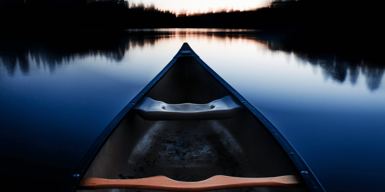 blue canoe heading towards horizon