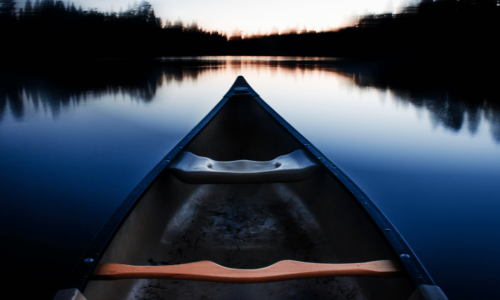 blue canoe heading towards horizon