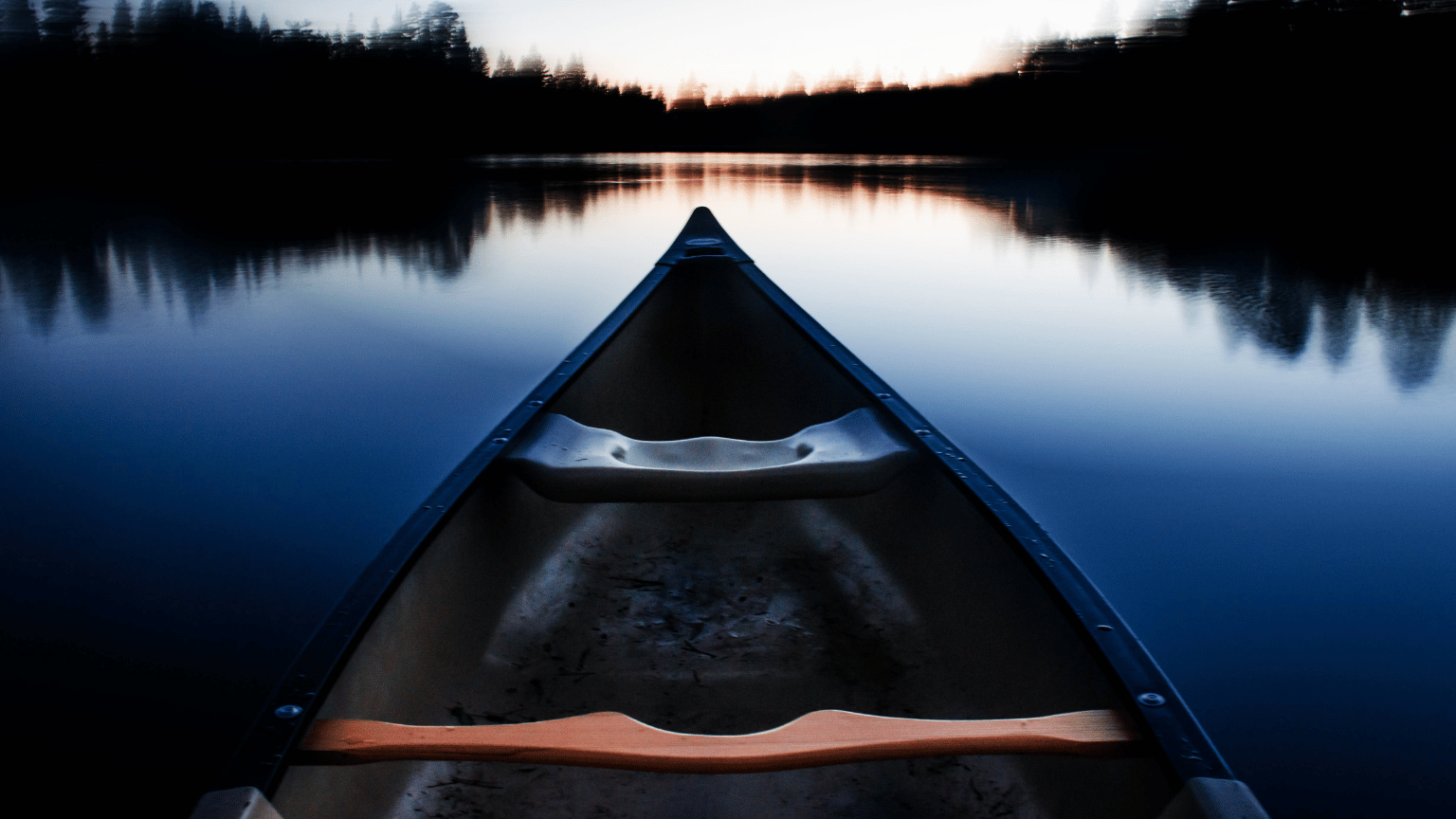 blue canoe heading towards horizon